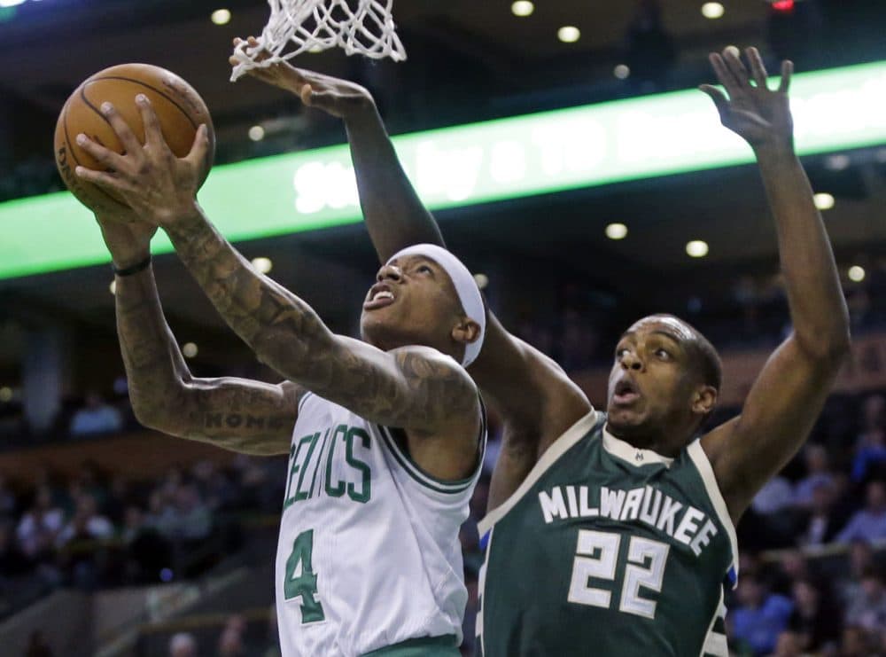 Boston Celtics guard Isaiah Thomas (4) puts up a reverse layup against the defense of Milwaukee Bucks guard Khris Middleton (22) during last night's game. (Elise Amendola/AP)