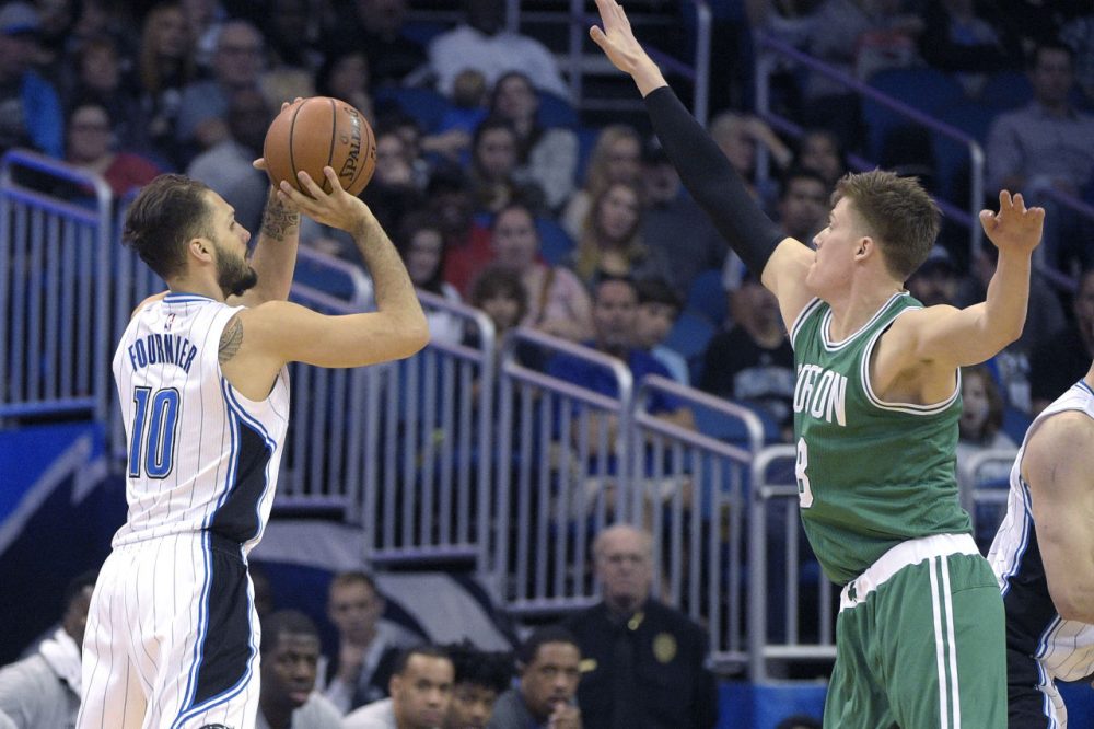 Magic guard Evan Fournier puts up a three-pointer in front of Celtics forward Jonas Jerebko during Sunday's game in Orlando. The Magic won 119-114. (Phelan M. Ebenhack/AP)