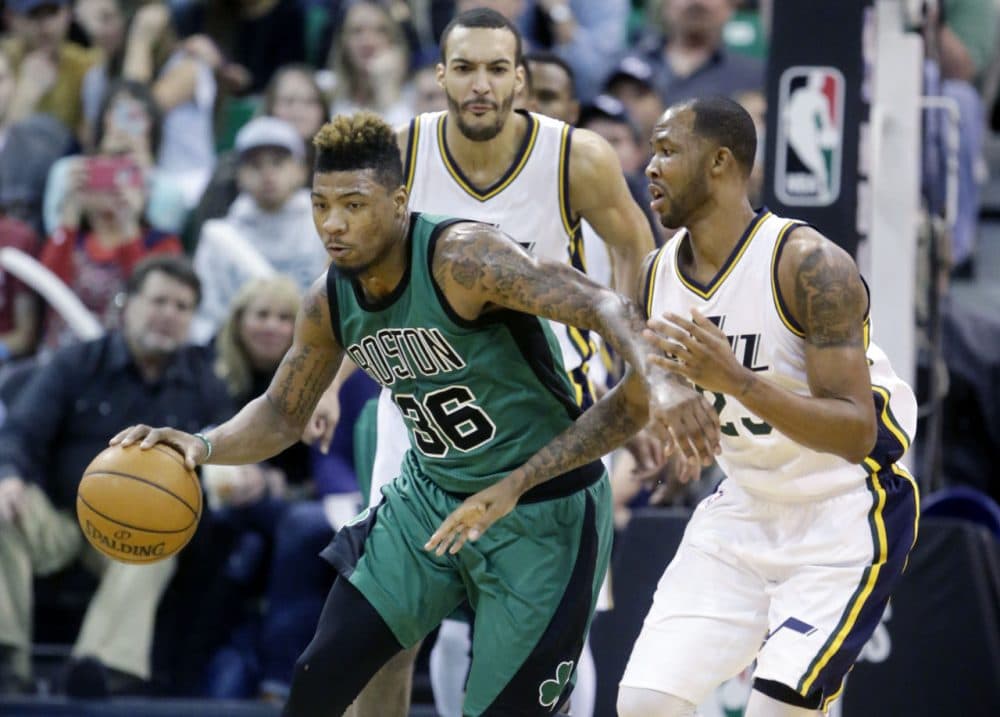 Celtics guard Marcus Smart (36) drives around Utah Jazz's Chris Johnson, right, as Rudy Gobert, rear, looks on during Friday night's game in Salt Lake City. (Rick Bowmer/AP)