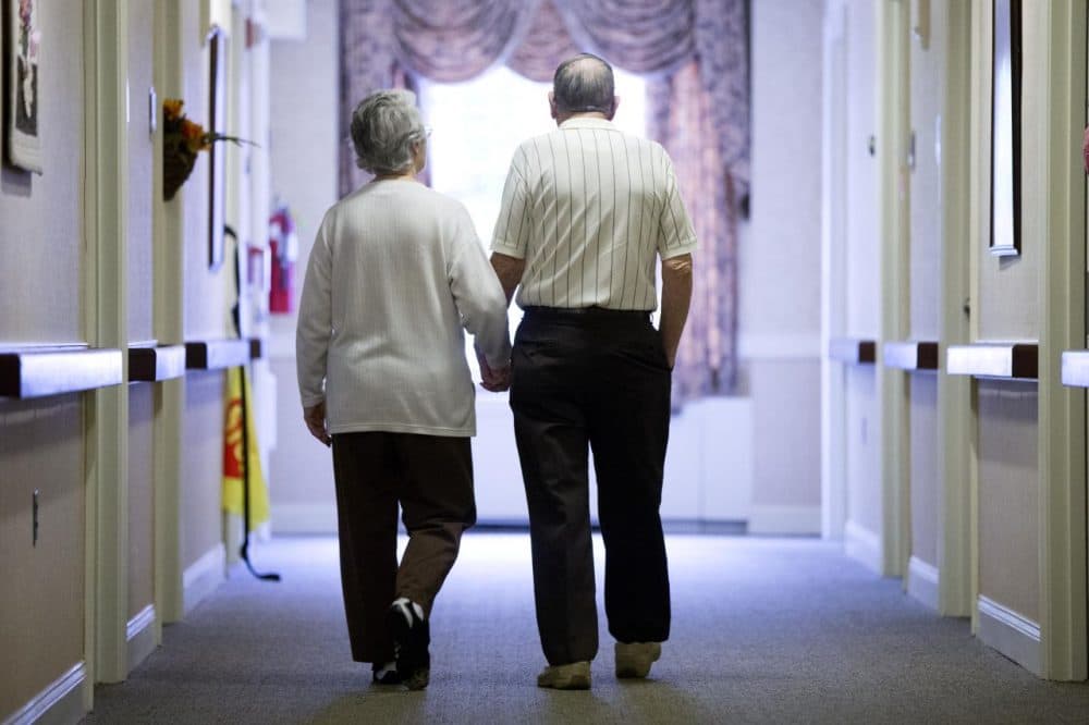 Decima Assise, who has Alzheimer's disease, and Harry Lomping walk the halls, Friday, Nov. 6, 2015, at The Easton Home in Easton, Pa. (Matt Rourke/AP)