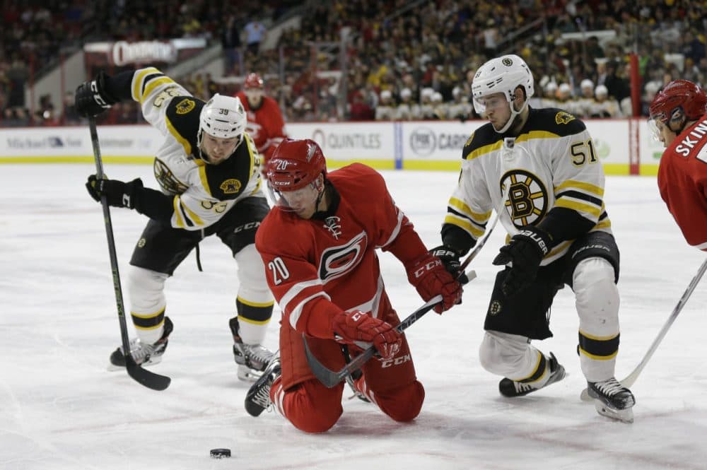 Bruins' Matt Beleskey (39) and Ryan Spooner (51) struggle with Carolina Hurricanes' Riley Nash (20) during a game in Raleigh, North Carolina Friday night. (Gerry Broome/AP)
