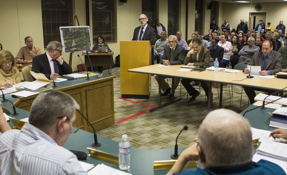 Representing the Islamic Center of Greater Worcester, attorney Jason Talerman (standing) addresses the Dudley Zoning Board in front of a packed room Thursday night. (Jesse Costa/WBUR)