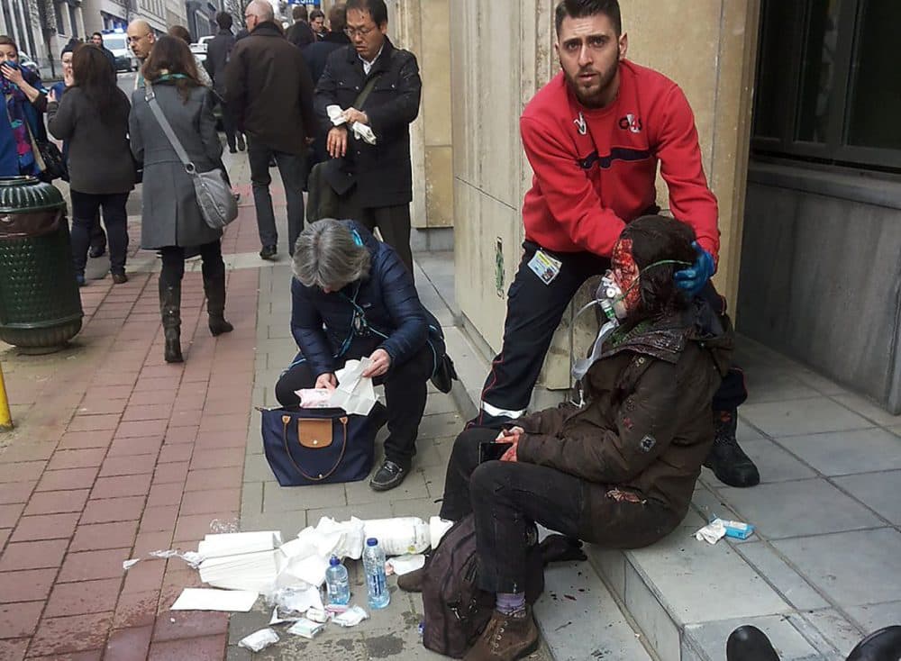 A private security guard helps a wounded women outside the Maalbeek metro station in Brussels on March 21, 2016 after a blast at this station located near the E.U. institutions.
Belgian firefighters said at least 26 people had died after "enormous" blasts rocked Brussels airport and a city metro station today, as Belgium raised its terror threat to the maximum level. (Michael Villa/AFP/Getty Images)