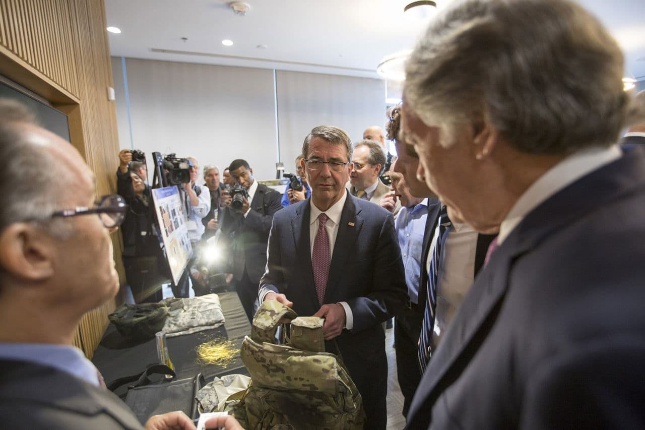 U.S. Defense Secretary Ash Carter, alongside Rep. Joseph Kennedy III and Sen. Ed Markey, examines some items made with innovative textiles at MIT Friday. (Joe Difazio for WBUR)
