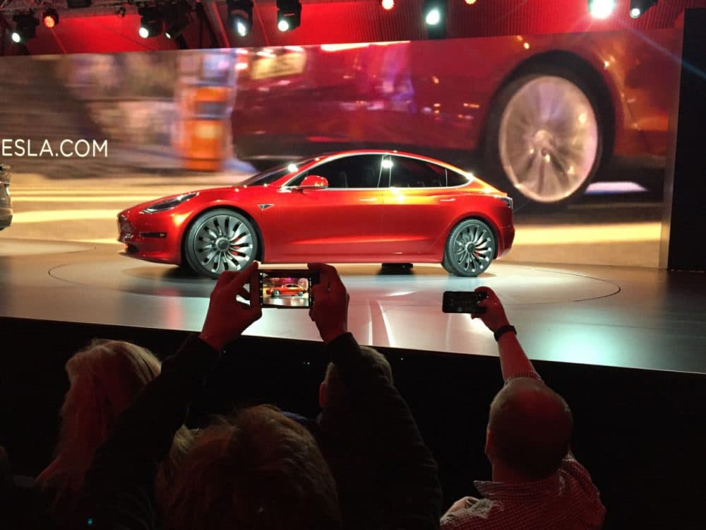 Tesla Motors unveils the new lower-priced Model 3 sedan at the Tesla Motors design studio Thursday, March 31, 2016, in Hawthorne, Calif. It doesn't go on sale until late 2017, but in the first 24 hours that order banks were open, Tesla said it had more than 115,000 reservations. Long lines at Tesla stores, reminiscent of the crowds at Apple stores for early models of the iPhone, were reported from Hong Kong to Austin, Texas, to Washington, D.C. Buyers put down a $1,000 deposit to reserve the car. (AP Photo/Justin Prichard)