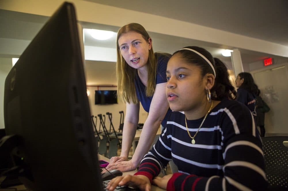 Volunteer Charity Leschinski, left, helps student Janae Bush-de la Cruz debug a program during a Girls Who Code meeting sponsored by Brookview House in Roxbury. (Jesse Costa/WBUR)