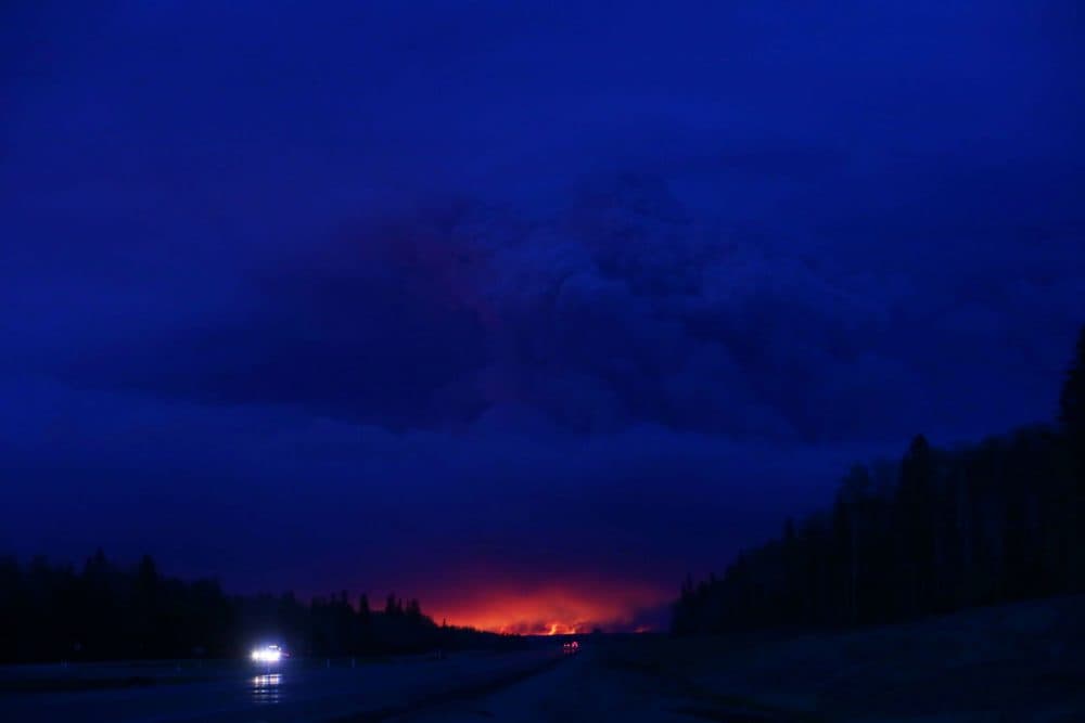 A plume of smoke hangs in the air as forest fires rage on in the distance in Fort McMurray, Alberta on May 4, 2016.
Numerous vehicles can be seen abandoned on the highways leading from the raging forest fires in Fort McMurray and neighbouring communities have banded together to offer support in the form of food, water, and gasoline. (Cole Burston/AFP/Getty Images)