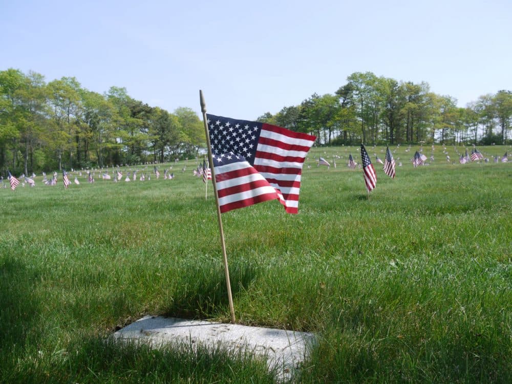 Hundreds of volunteers American flags on the more than 60,000 graves at the Massachusetts National Cemetery on Cape Cod for the Memorial Day holiday. (Alex Ashlock/Here & Now)