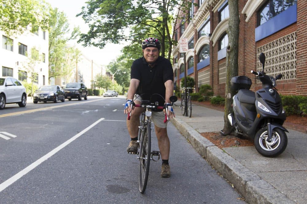 Bruce Gellerman on his bike outside WBUR's offices after both knee surgeries. (Joe Difazio for WBUR)