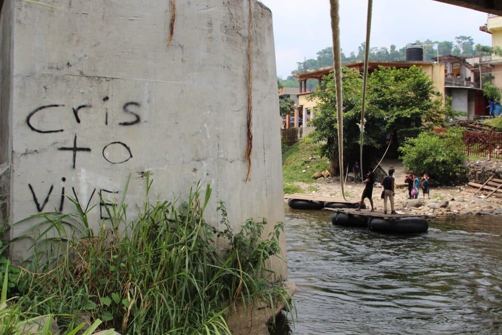 The words read, "Christ Lives." Migrants and goods such as oil and foodstuffs are transported illegally on a raft below this bridge, an official port of entry linking Mexico and Guatemala. (Lorne Matalon/Fronteras)