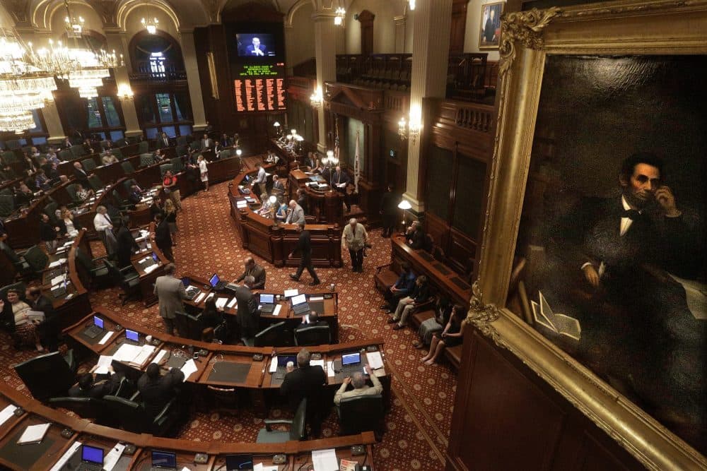 A portrait of Abraham Lincoln overlooks lawmakers as they debate legislation while on the House floor during session at the Illinois State Capitol in Springfield, Illinois. (Seth Perlman/AP)