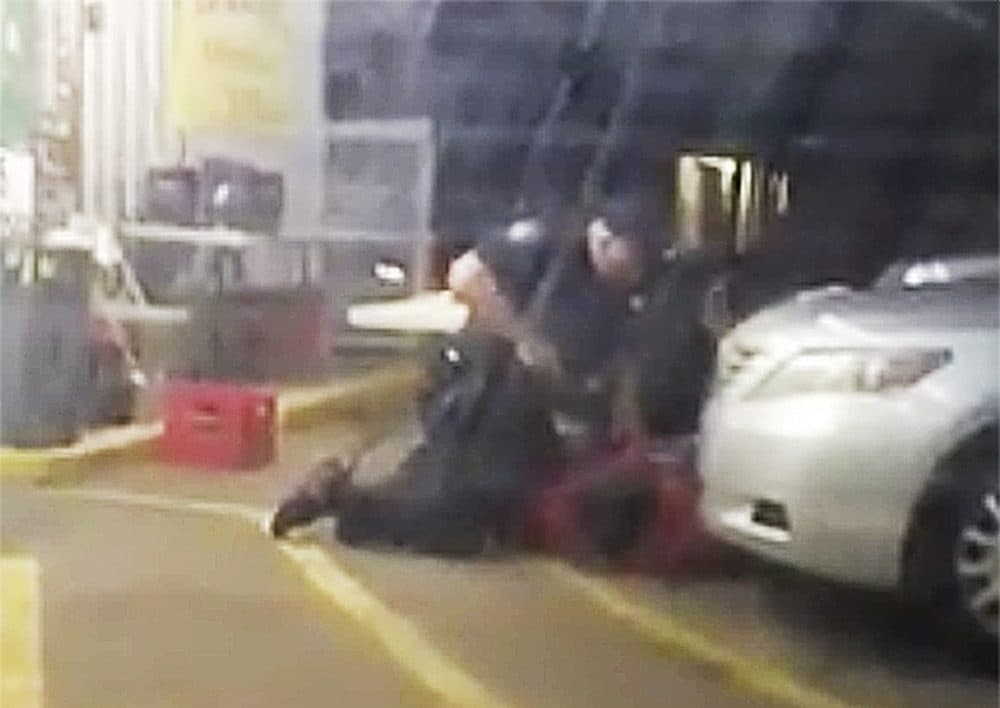 In this Tuesday, July 5, 2016 photo made from video, Alton Sterling is held by two Baton Rouge police officers, with one holding a hand gun, outside a convenience store in Baton Rouge, La. Moments later, one of the officers shot and killed Sterling, a black man who had been selling CDs outside the store, while he was on the ground. (Arthur Reed via AP)