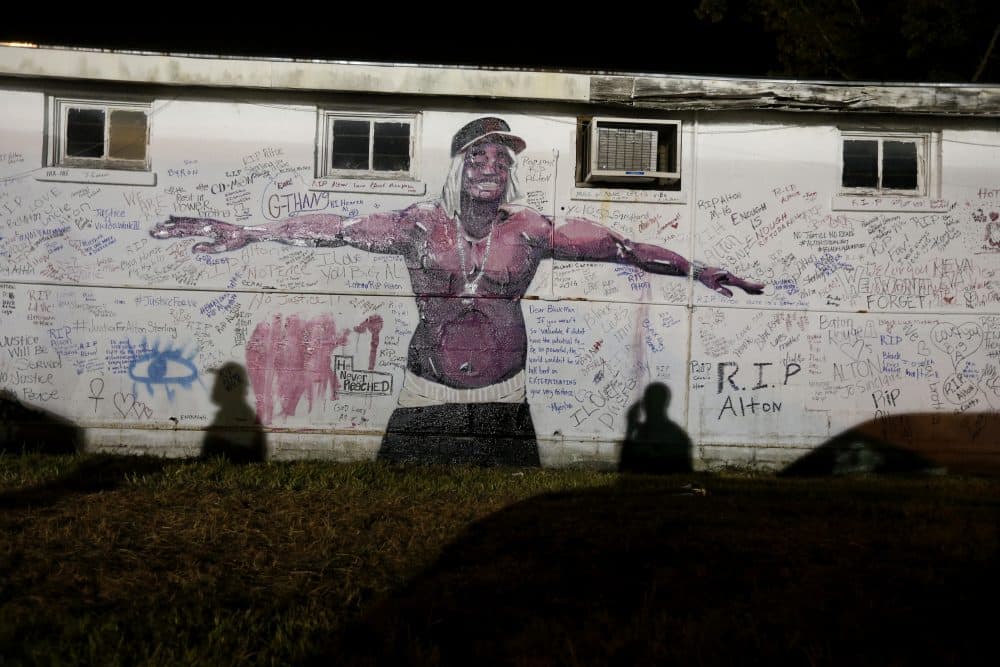 Shadows fall on a newly painted mural of Alton Sterling next to the Triple S convenience store in Baton Rouge, La., Wednesday, July 6, 2016. (Gerald Herbert/AP)