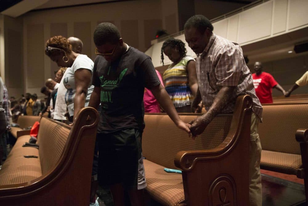Parishioners of Frienship-West Baptist Church in Dallas, Texas, pray together on July 10, 2016, during a "Community Conversation" event following the recent sniper attacks against white police officers.
The Dallas gunman was plotting a major bomb attack, authorities said, urging calm after more than 200 people were arrested in a new night of protests over police violence against blacks. (Laura Buckman/AFP/Getty Images)