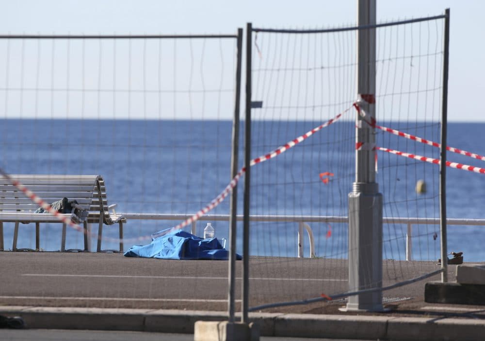 A body of a victim covered by sheets lays at the scene of a truck attack in Nice, southern France, Friday, July 15, 2016. A large truck mowed through revelers gathered for Bastille Day fireworks in Nice, killing more than 80 people and sending people fleeing into the sea as it bore down for more than a mile along the Riviera city's famed waterfront promenade. (Luca Bruno/AP)