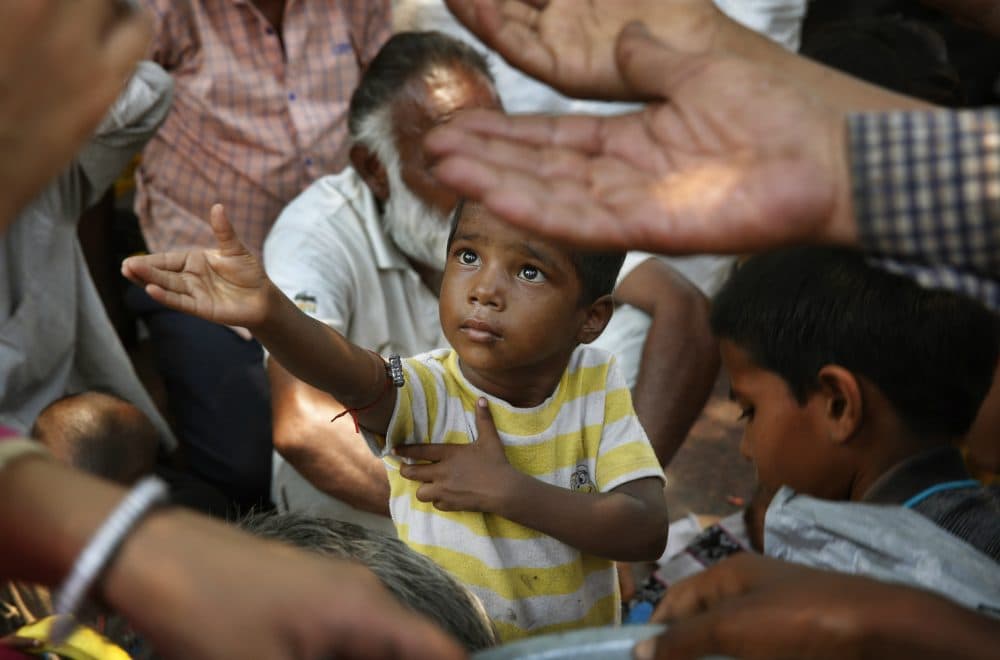 Joelle Renstrom: "People who struggle to meet basic needs such as food, water, shelter and security have bigger concerns than internet access."
Pictured: An Indian child stretches arms to receive free food being distributed outside a Hindu temple, in New Delhi, India, where countless children live with grinding poverty, sleep on sidewalks, beg at traffic intersections and rely on government-run lunch programs that often provide their only full meal for the day. (Manish Swarup/AP)