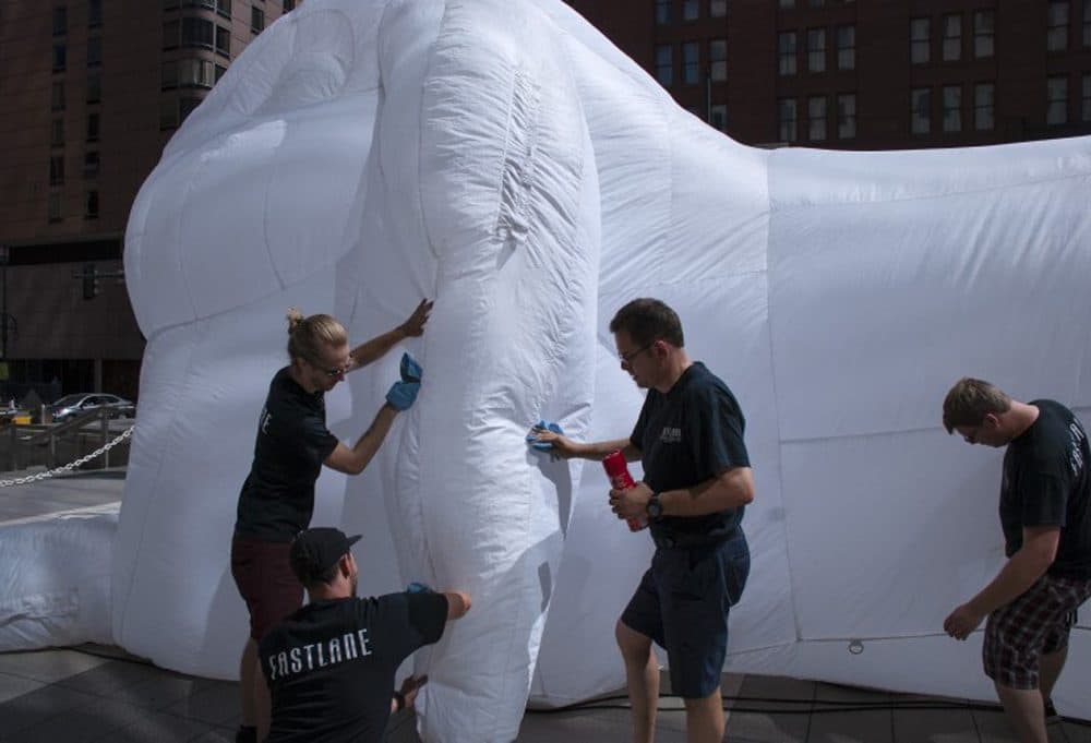 Doug Lane (center) and his Fastlane Productions team clean one of five inflatable rabbit sculptures by Australian artist Amanda Parer that appeared in Denver in June as part of a series called "Intrude" commissioned by Arts Brookfield. (Corey H. Jones/CPR News)