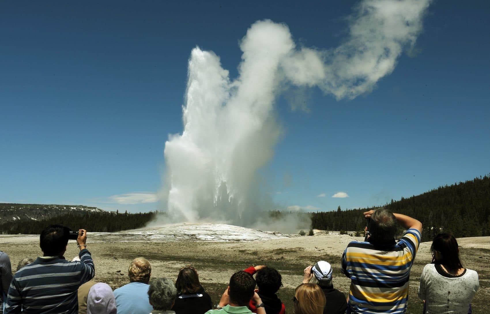 Tourists watch the "Old Faithful" geyser, which erupts on average every 90 minutes, at Yellowstone National Park in Wyoming on June 1, 2011. (Mark Ralston/AFP/Getty Images)