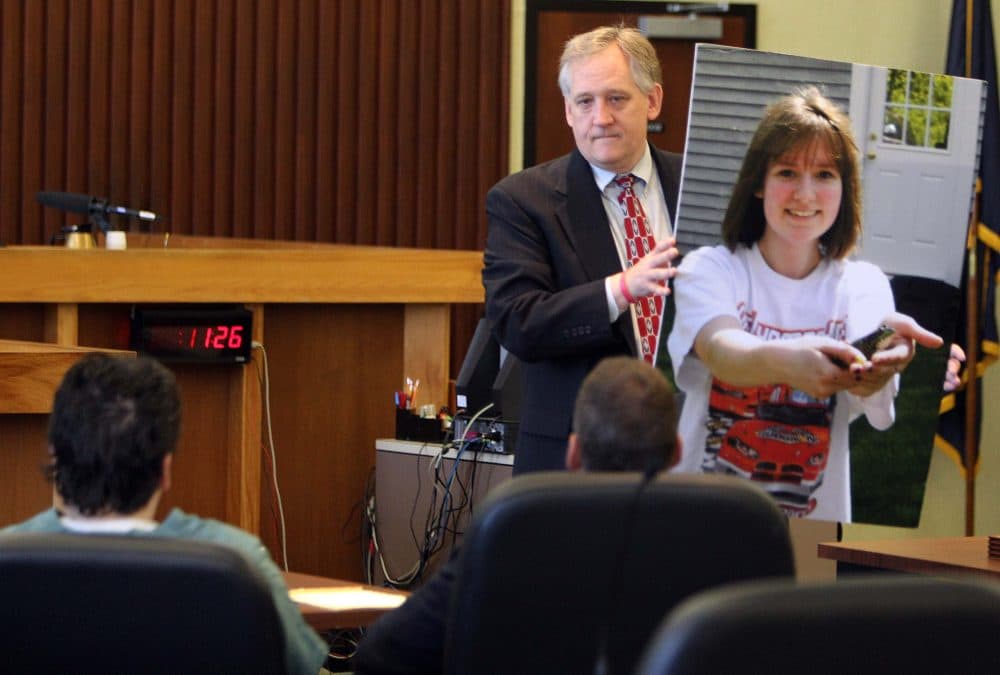 Bob Marriott holds a large photo of his daughter Elizabeth "Lizzy" Marriott as he looks at Seth Mazzaglia, seated left, during a sentencing hearing in Strafford County Superior Court, Thursday, Aug. 14, 2014, in Dover, N.H. Mazzaglia was convicted of killing Elizabeth Marriott and was sentenced to life in prison. (Jim Cole/AP)