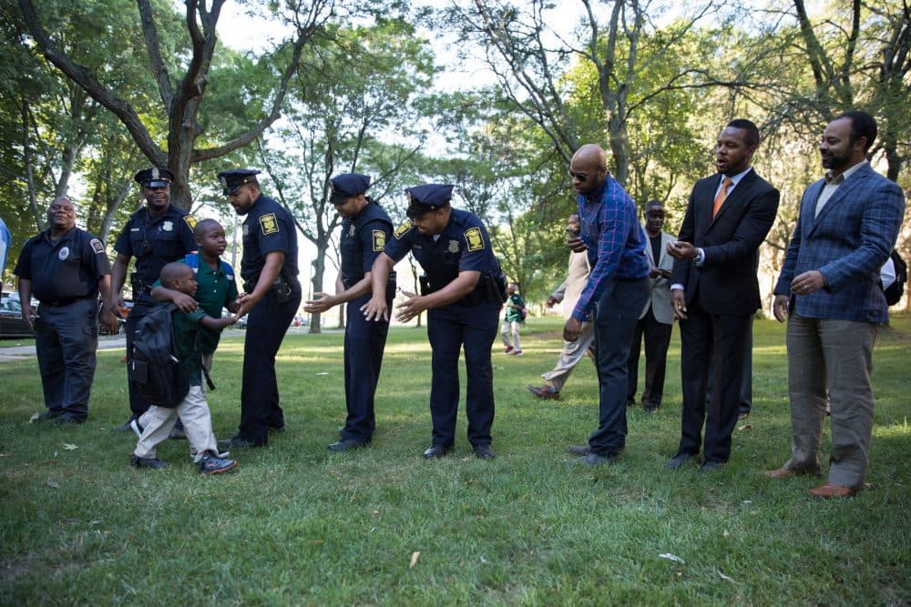 Black men from all walks of life lined up to welcome Hartford students back to school with high fives and messages of encouragement. (Ryan Caron King/WNPR)