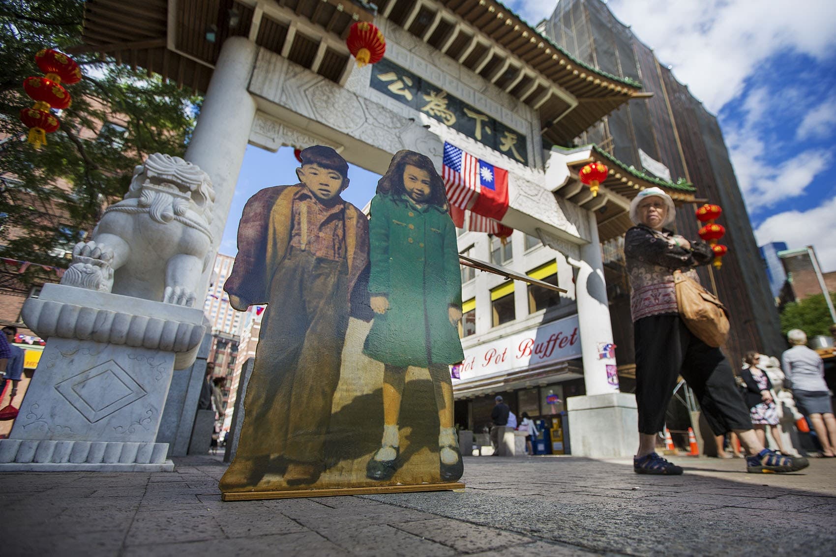 "Two Kids" stand at the Chinatown Gate as part of artist Wen-Ti Tsen's "Home Town" installation. (Jesse Costa/WBUR)