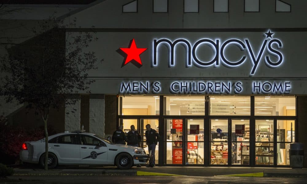 Law enforcement officers stand outside to the entrance of Macy's at the Cascade Mall where several people were shot and killed Friday Sept. 23, 2016 in Burlington, Wash. Police searched Saturday for a gunman who opened fire in the makeup department of a Macy's store at the mall north of Seattle, killing several females, before fleeing toward an interstate on foot, authorities said. (Stephen Brashear/AP)
