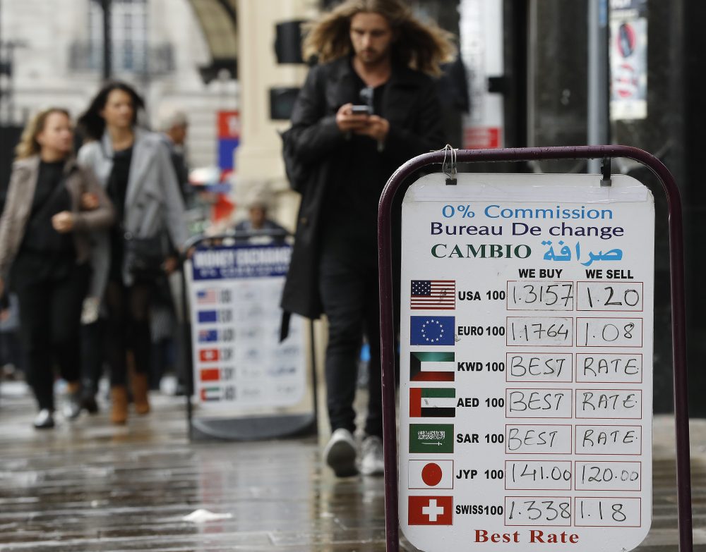 People pass currency exchange boards in London, Wednesday, Oct. 12, 2016. (Frank Augstein/AP)