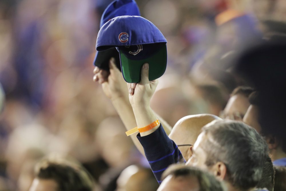 Fans raise their caps during the national anthem before Game 6 of the National League baseball championship series between the Chicago Cubs and the Los Angeles Dodgers, Saturday, Oct. 22, 2016, in Chicago. (Charles Rex Arbogast/AP)