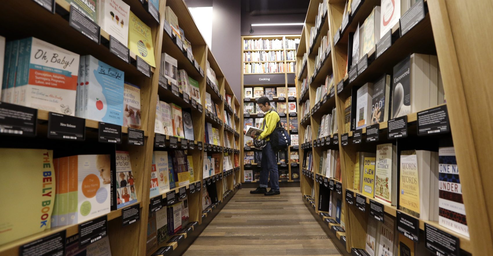 A customer shops at the opening day for Amazon Books, the first brick-and-mortar retail store for online retail giant, on Nov. 3, 2015, in Seattle. (Elaine Thompson/AP)
