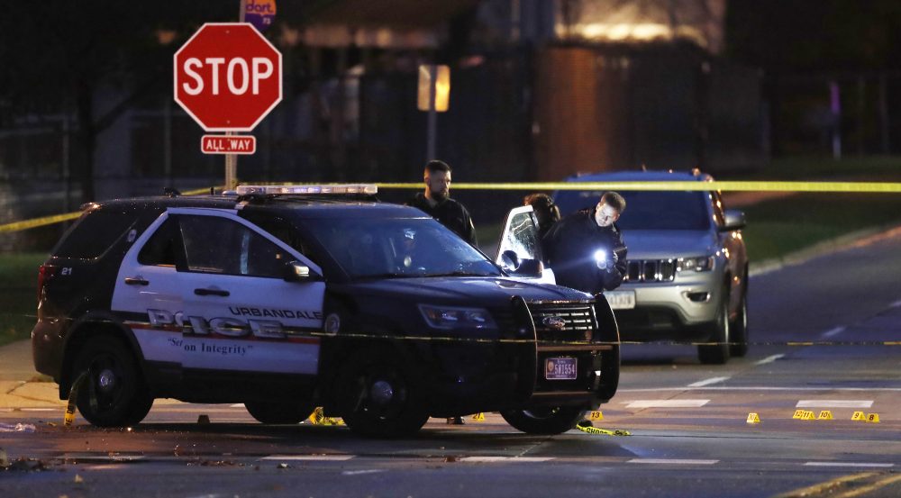 Police officers gather evidence at the scene of a shooting, Wednesday, Nov. 2, 2016, in Urbandale, Iowa. Two Des Moines area police officers were shot to death early Wednesday in ambush-style attacks while they were sitting in their patrol cars, and police are searching for suspects, authorities said. (Charlie Neibergall/AP)