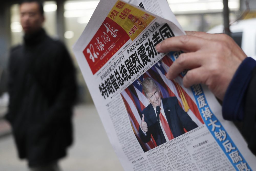 A man reads a newspaper with the headline of "U.S. President-elect Donald Trump delivers a mighty shock to America" at a news stand in Beijing on Nov. 10, 2016. (Andy Wong/AP)