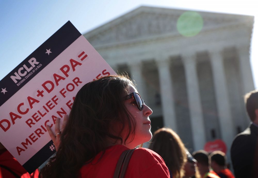 A pro-immigration activist holds a sign in front of the U.S. Supreme Court on April 18, 2016 in Washington, D.C. (Alex Wong/Getty Images)