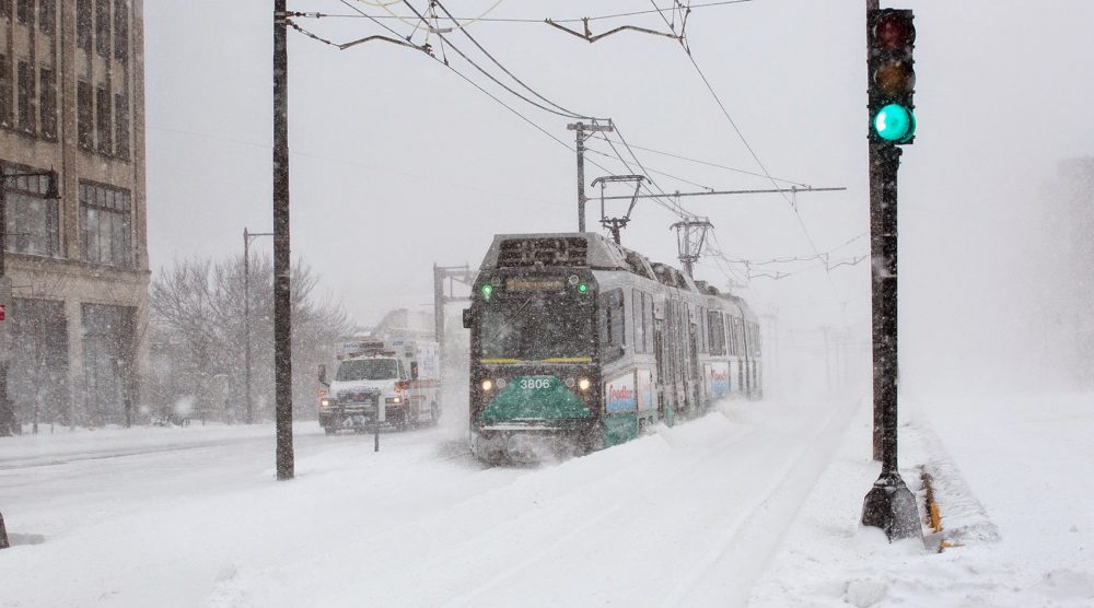 Emerging from a snowstorm, a Green Line train runs along Commonwealth Avenue. (Robin Lubbock/WBUR) 