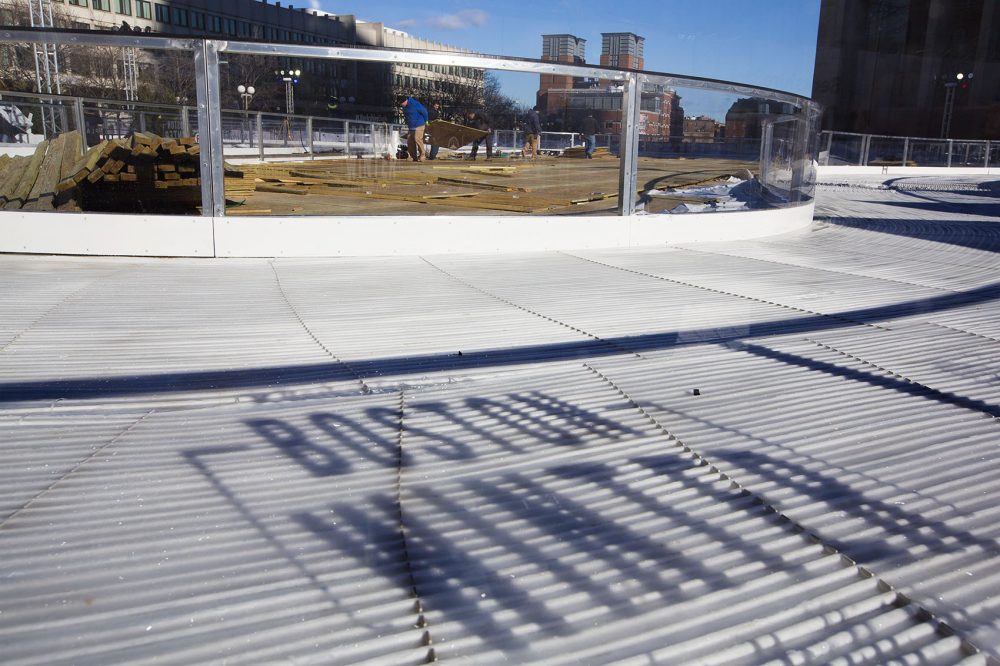 Workers build the final pieces of the skating rink scheduled to open on Saturday for the Boston Winter at City Hall Plaza. (Jesse Costa/WBUR)