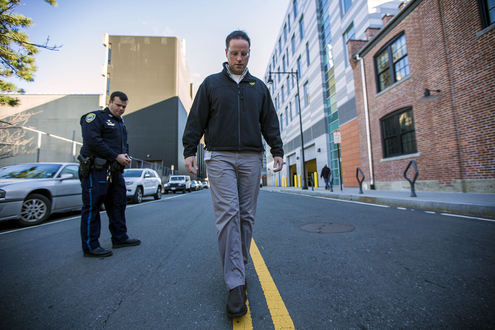Cambridge Police officer Jason Callinan and Jeremy Warnick, a spokesman for the department, demonstrate the walk and turn line test down the center of Rogers Street. (Jesse Costa/WBUR)