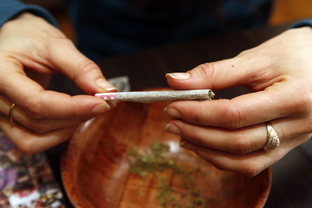 Rica Madrid poses for a photograph as she rolls a joint in her home on the first day of legal possession of marijuana for recreational purposes, Thursday, Feb. 26, 2015, in Washington. (Alex Brandon/AP)