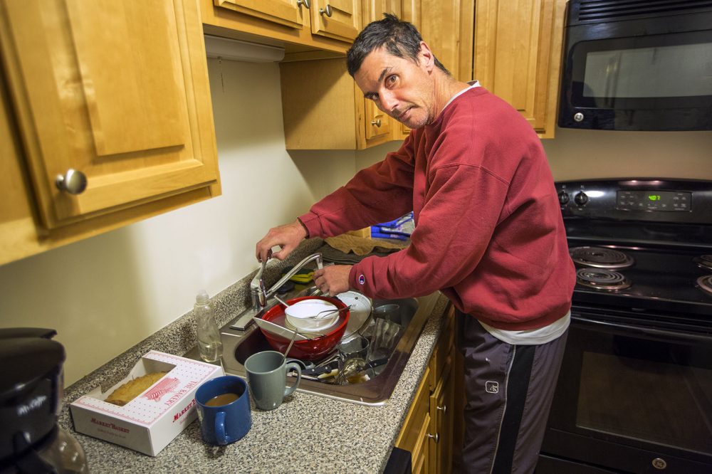 Joey gets a glass of water in the kitchen of his new apartment. (Jesse Costa/WBUR)