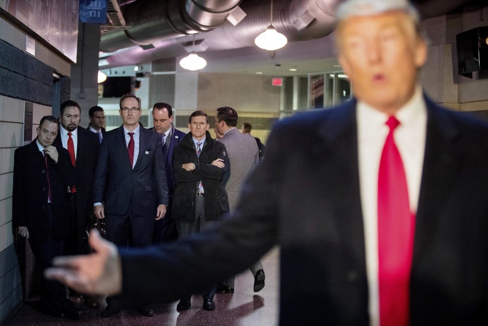 President-elect Donald Trump's Chief of Staff Reince Priebus, left; Jason Miller, a senior adviser, second from left; Boris Epshteyn, a spokesman for Trump, fourth from left, and Michael Flynn, Trump's nominee for National Security adviser, fifth from left, listen as Trump speaks to members of the media on Thursday, Dec. 8, 2016. (Andrew Harnik/AP)
