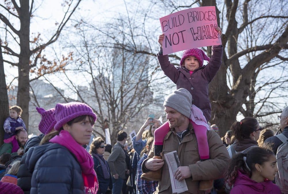Lilli, 5, sat on her father Alex Lang's shoulders with a sign saying "Build Bridges Not Walls," at the Women's March for America. (Robin Lubbock/WBUR)