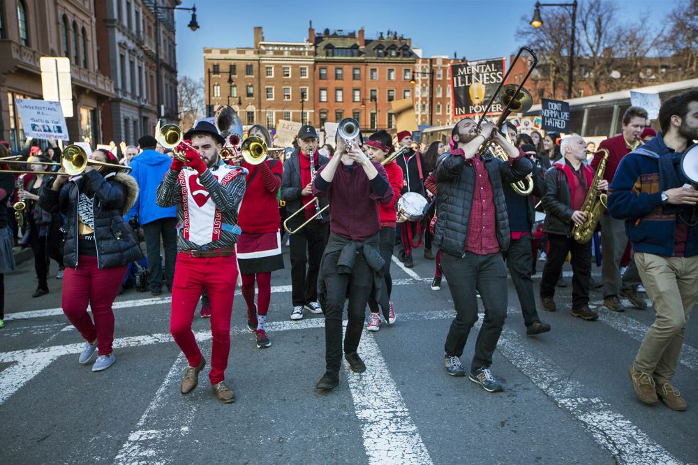 Somerville’s Second Line Social Aid and Pleasure Society Brass Band plays while marching down Arlington Street in Boston during the Women's March for America. (Jesse Costa/WBUR)