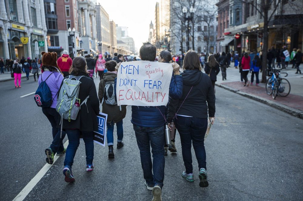 A man holds a sign that reads: "Men of quality don't fear equality." (Jesse Costa/WBUR)