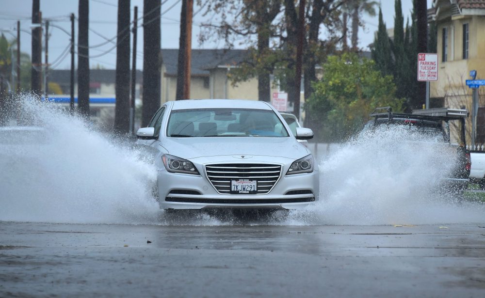 A vehicle is driven along a flooded street in Monterey Park, Calif., on Jan. 23, 2017 following another night of rain. (Frederic J. Brown/AFP/Getty Images)