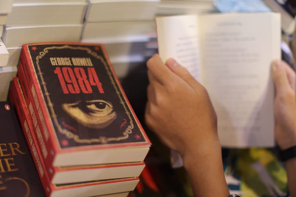 A boy reads a book next to copies of George Orwell's "1984" at Hong Kong's annual book fair in July 2015. (Aaron Tam/AFP/Getty Images)