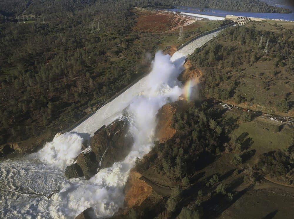 This Saturday, Feb. 11, 2017, aerial photo released by the California Department of Water Resources shows the damaged spillway with eroded hillside in Oroville, Calif. Water will continue to flow over an emergency spillway at the nation's tallest dam for another day or so, officials said Sunday. (William Croyle/California Department of Water Resources via AP)