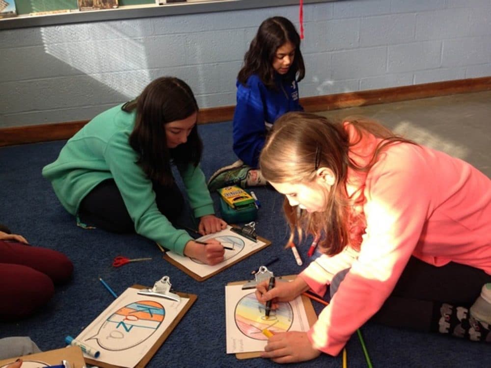 Fifth graders at Leeds Elementary School in Northampton color the word “kaza” which means “welcome” in Kirundi, the language of Burundi. (Nancy Eve Cohen/NEPR)