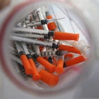 In this 2015 photograph, a jug of used needles to exchange for new is seen near an industrial area of Camden, N.J. (Mel Evans/AP)