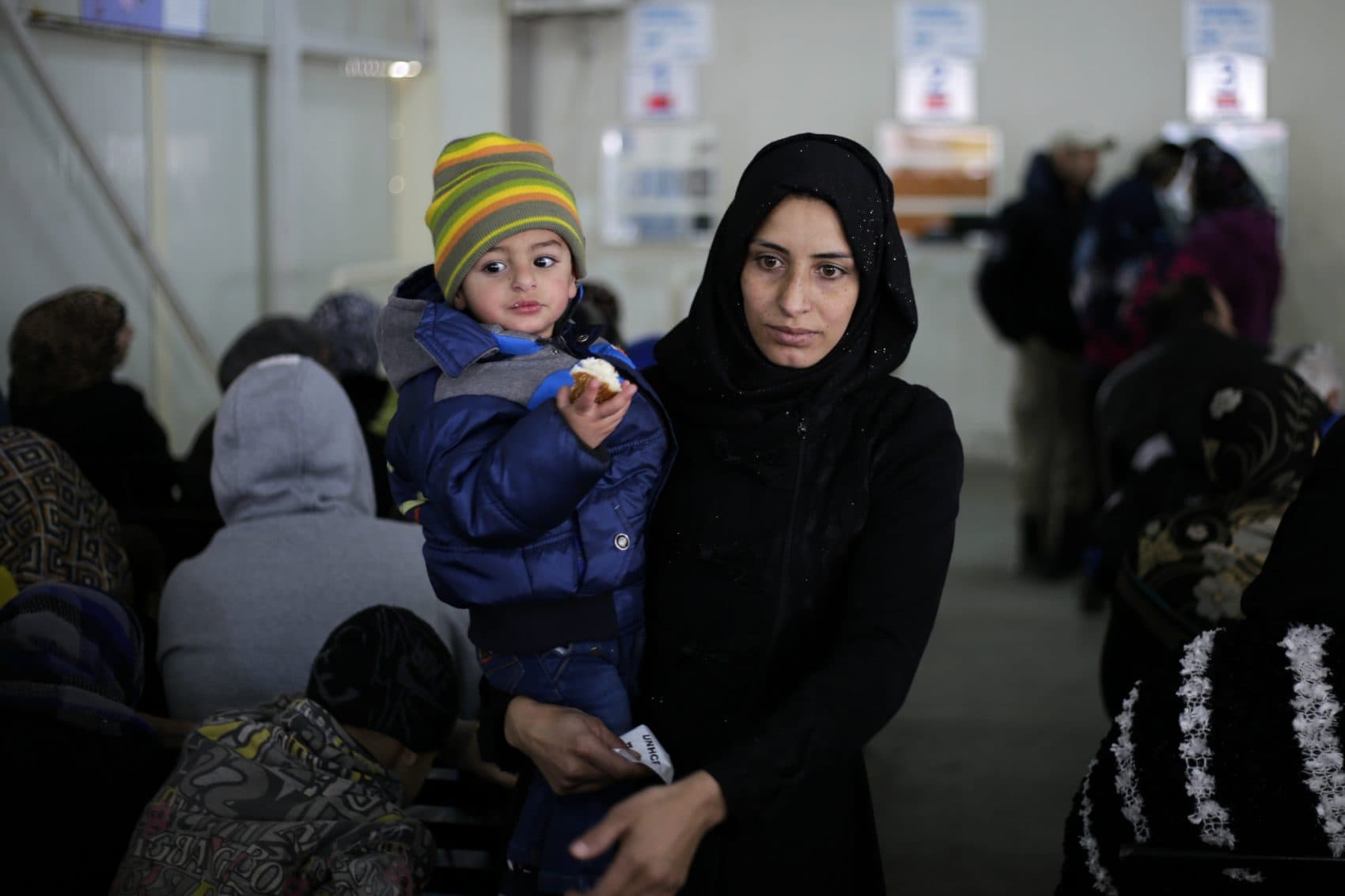 Immigration lawyer Kari Hong writes that an act of Congress, not an executive order, is the proper means of resolving refugee and asylum admissions. Pictured: A Syrian boy eats bread as he waits in line with his mother as hundred of Syrian families wait to register at the United Nations High Commissioner for Refugees headquarters, in Beirut, Lebanon, Monday, Jan. 30, 2017. By executive order, U.S. President Donald Trump imposed a 90-day ban, Friday, that affects travel to the U.S. by citizens of Iraq, Syria, Iran, Sudan, Libya, Somalia and Yemen and puts an indefinite hold on a program resettling Syrian refugees. (Hassan Ammar/AP)