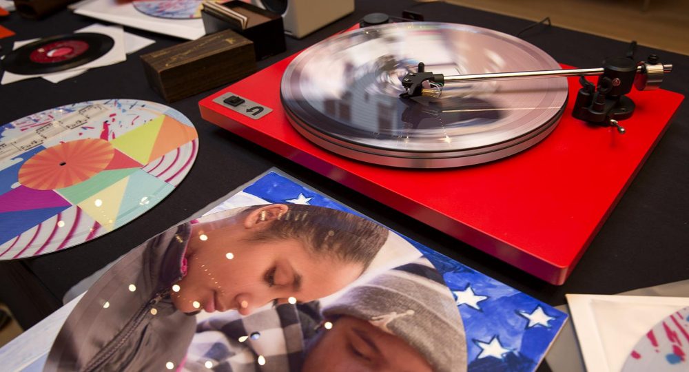 Vinyl spins on the "Sound Lab" turntable, surrounded by albums designed by students. (Robin Lubbock/WBUR)