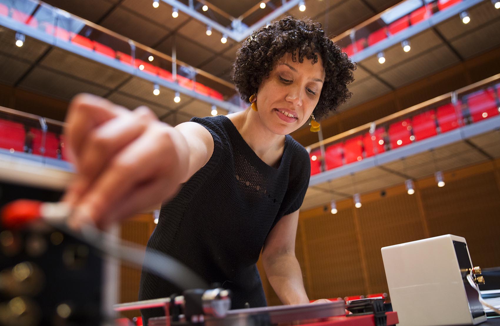 Artist Elisa Hamilton adjusts the volume of the "Sound Lab" turntable. (Robin Lubbock/WBUR)