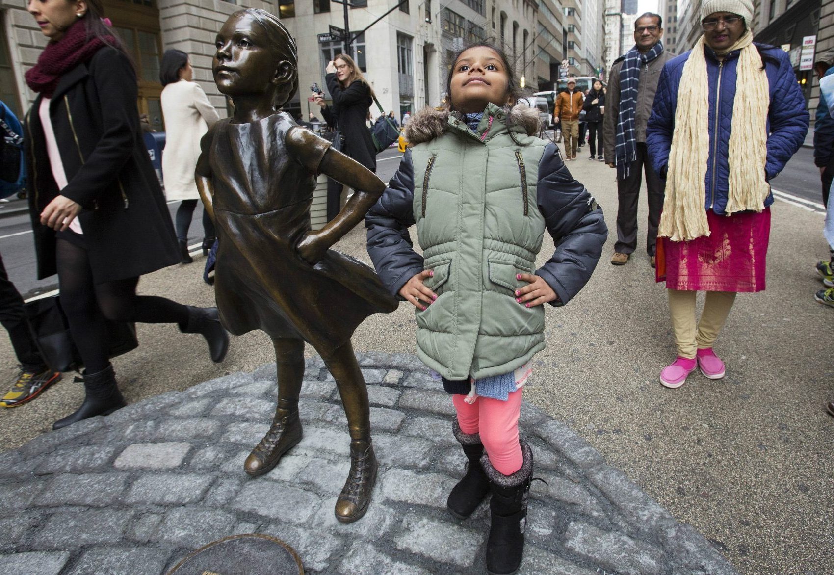 Twice as many girls were taught to be nice and respectful, writes Deborah Pine, as those taught to be leaders. Pictured: Shriya Gupta of Cherokee, N.C. strikes a pose with a statue titled "Fearless Girl," Wednesday, March 8, 2017, in New York. The statue was installed by an investment firm in honor of International Women's Day. (Mark Lennihan/AP)